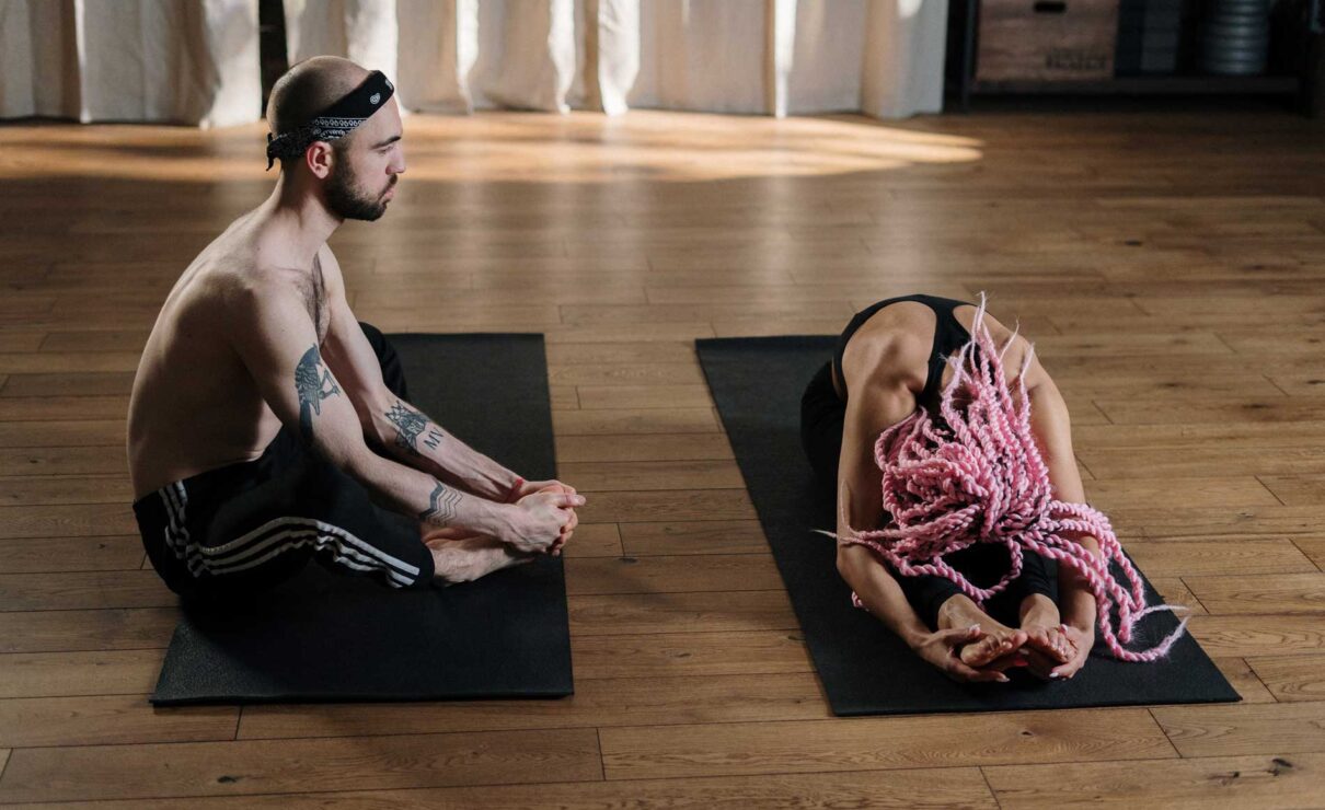 Two people stretching as part of their Training Program.